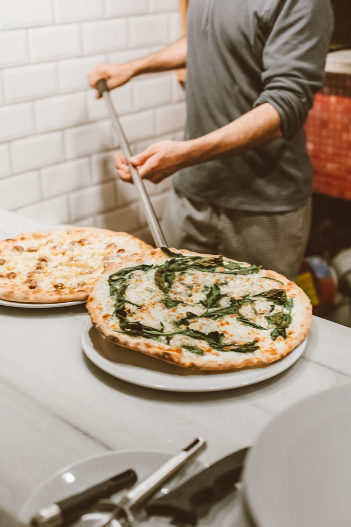 about-us-02 Professional pizzaiolo prepares traditional pizzas in a cozy Italian restaurant.